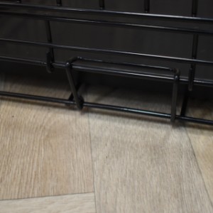 Le bac de la cage pour chien Strong L est maintenu par un loquet noir