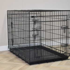 La cage pour chien XL est dotée de barreaux solides avec un revêtement noir thermolaqué